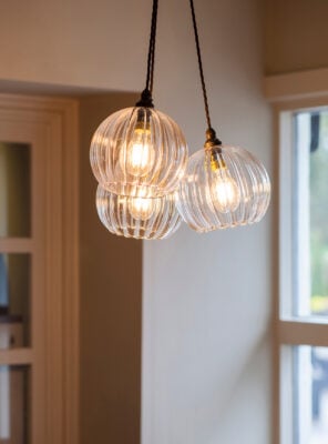 Featured here is the Hereford pendant cluster chandelier by Fritz Fryer, featuring 3 ribbed glass pendant lights