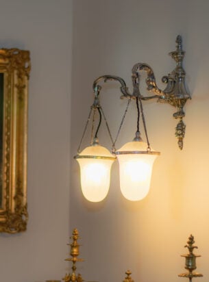 Double arm Antique wall lights attributed to Osler, featured within a hallway.