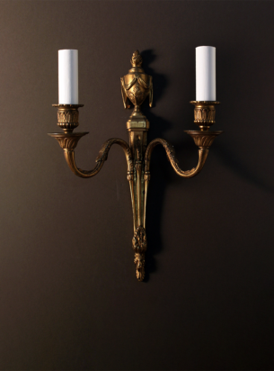 A fine example of antique wall lights featuring 2 branches and gadroon and flame details in gilt metal finish
