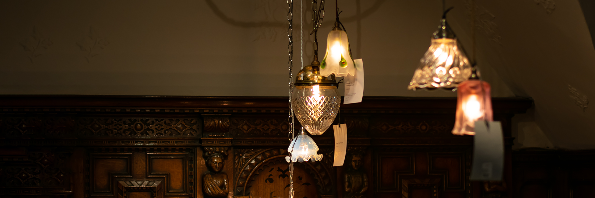 Antique ceiling lights hung together in a pretty display with eau de nil and cut glass shades