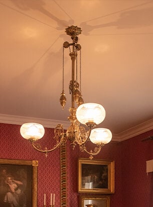 Antique ceiling light fitting suspended within the drawing room of the Holst museum in cheltenham