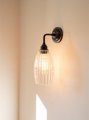 Ribbed glass shade featured on a bronze contemporary wall light, installed in a modern home