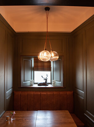 3 pendant cluster light set against dark panelled beams demonstrating how hotel chandeliers can really light a space