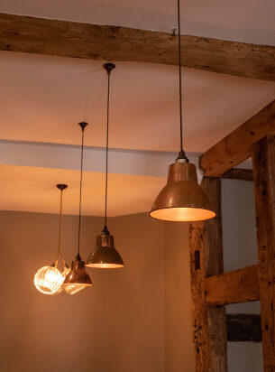 Industrial pendant lights look great hung in a row as featured here with 3 metal pendants