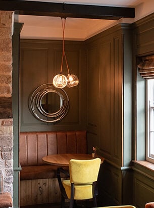 A cluster of glass globe pendants against wood panelled walls make perfect restaurant ceiling lights