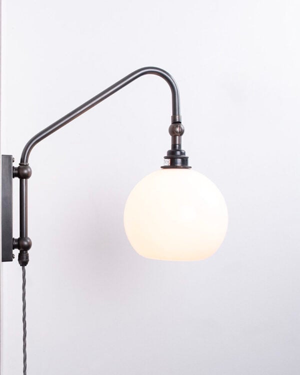 Swing arm wall light featuring Hereford globe by Fritz Fryer Lighting