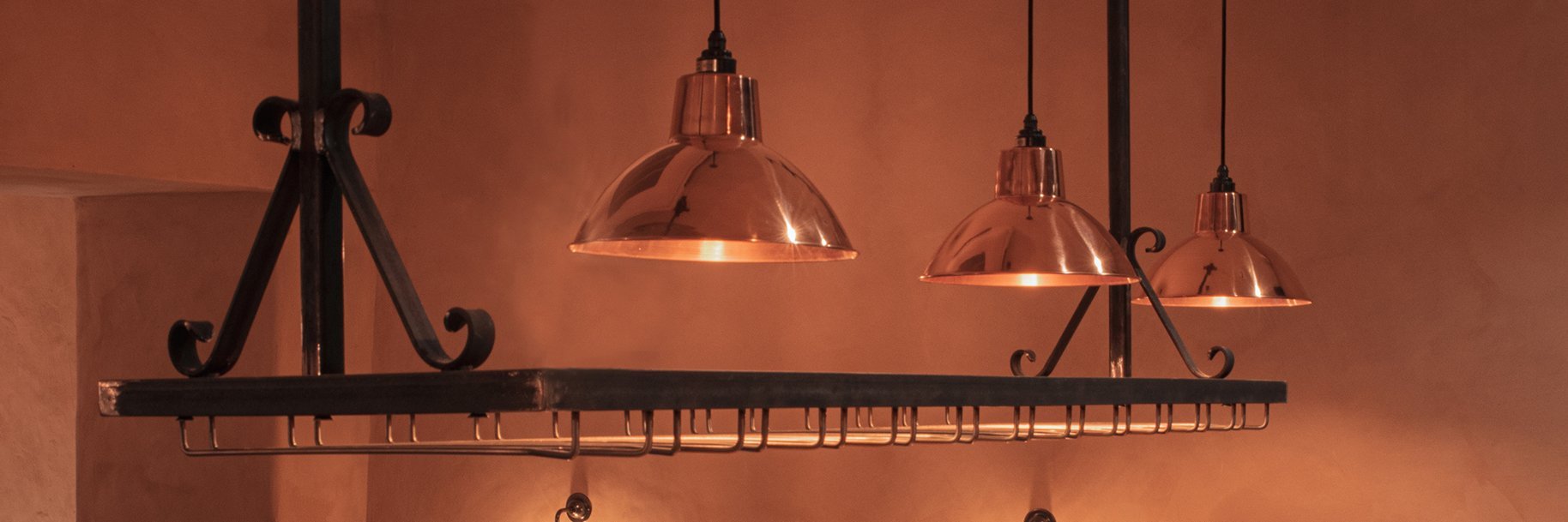 Sleek metal industrial lighting casting a warm glow over a countertop, perfect for both commercial and domestic spaces.