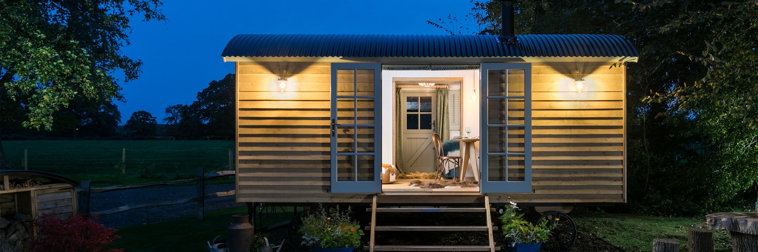Charming Shepards hut in a garden, featuring stylish outdoor lighting.