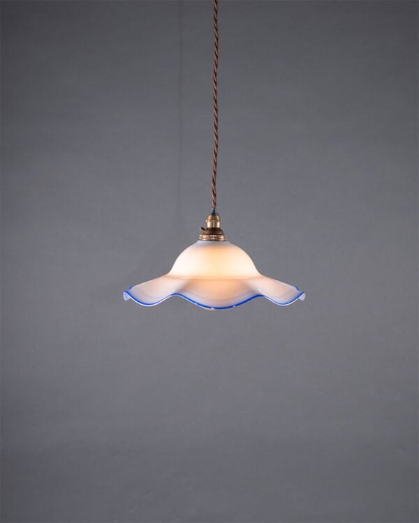 Pair of antique white and blue frilled pendant lights from the 1920s. Code: P106-PAIRS. Each light includes 65mm diameter brass ceiling plate, 2 meters of cotton flex, 2 B22 brass lampholders. Dimensions: Height 70mm, Width 220mm, Weight 300g. Perfect for traditional kitchens, dining rooms, or as decorative additions beside the bed.